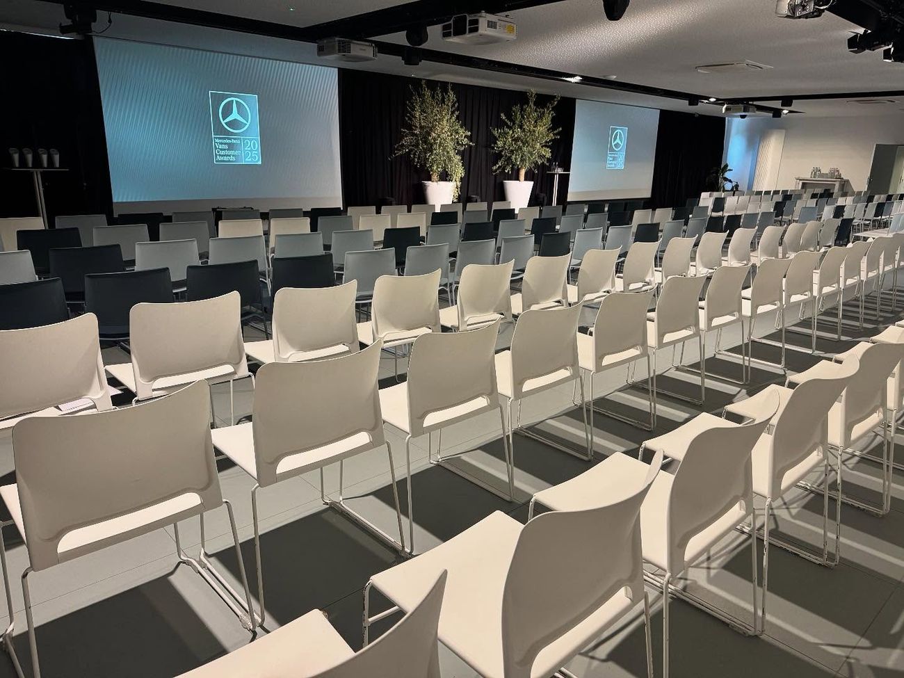 Conferentiezaal met rijen witte stoelen